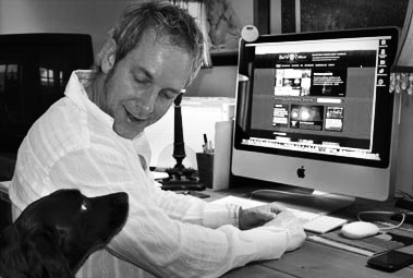 Photo of Steve Hall at work with dog looking on.